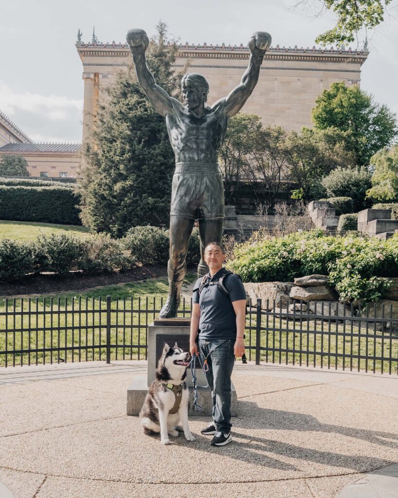 Gatsby the Siberian Husky with dog dad at Rocky Statue in dog-friendly Philadelphia.
