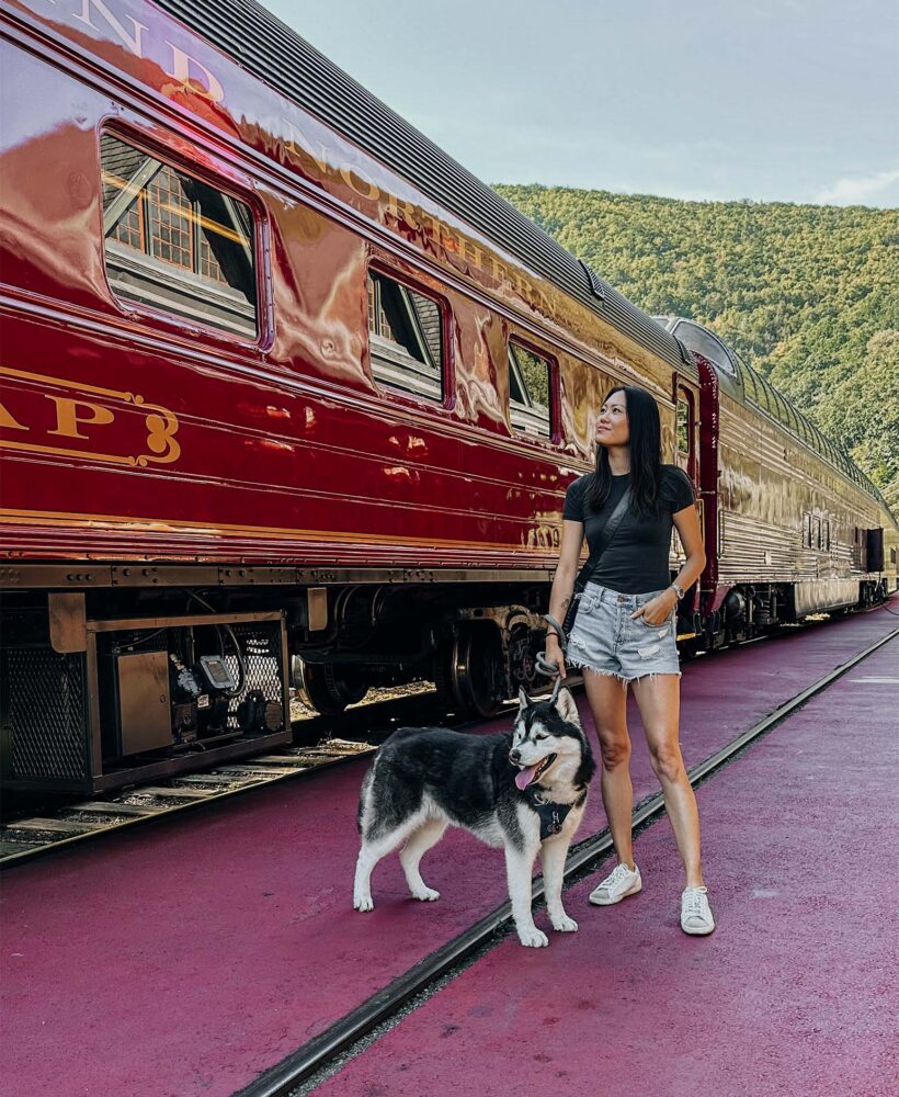 Siberian Husky and girl standing front of an old school diesel train in Lehigh Gorge Scenic Railway.